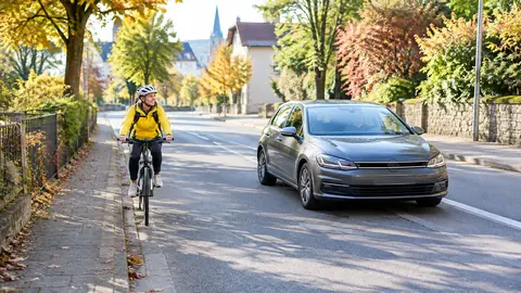 Ein Auto überholt eine Radfahrerin mit großem seitlichem Abstand