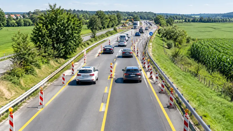 Autos fädeln an einer Baustelle auf der Autobahn abwechselnd im Reißverschlussverfahren ein
