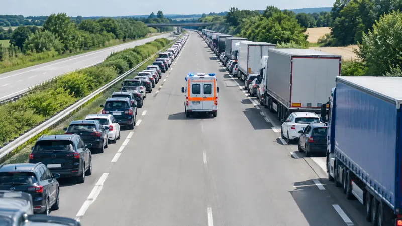 Luftbild einer Autobahn im Stau, die Autos bilden eine Rettungsgasse für einen Krankenwagen